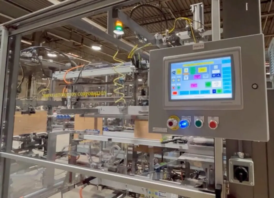 Industrial automation control panel with touchscreen interface and connected machinery in a packaging line.